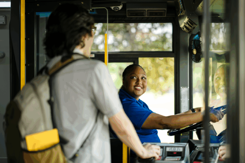 young man boards a bus and pays his fare